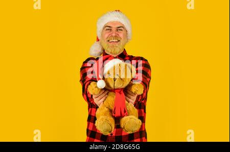 Santa Claus. Mature man with long beard. Christmas spirit. Christmas memories from childhood. Bearded man celebrate christmas. Kind hipster with teddy bear. Charity and kindness. Lovely hug. Stock Photo