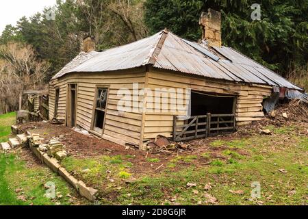 An old abandoned wooden farmhouse sinking into the earth. Photographed in New Zealand Stock Photo