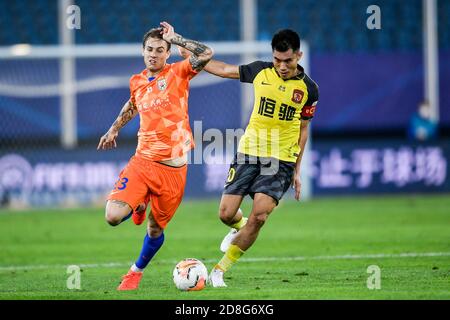 Brazilian football player Roger Krug Guedes, known as Roger Guedes, of Shandong Luneng Taishan F.C., left, struggles for the ball during the eleventh- Stock Photo