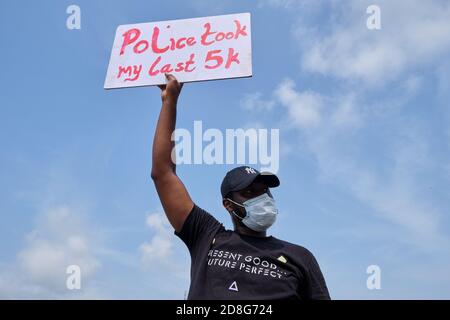 A protester hold a placard during protests against police brutality tagged #EndSARS in Lagos Nigeria on October 13, 2020. Stock Photo