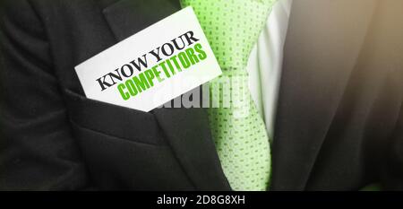 Businessman putting a card with text know your competitors in the pocket. Business concept Stock Photo