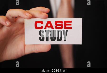 Case study, message on white card in hand of businessman Stock Photo