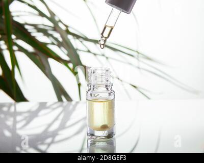 Drop falls from a pipette in a medical bottle close-up, isolated on a white background Stock Photo