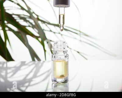 Drop falls from a pipette in a medical bottle close-up, isolated on a white background Stock Photo