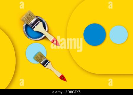 Abstract repair picture. One can of paint with paintbrushes to repair the apartment on a yellow background with colored circles made from paper. Stock Photo