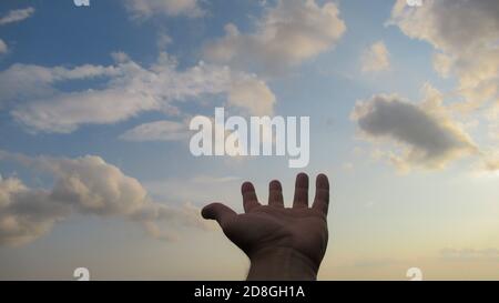 Hand of a man reaching to towards sky. Stock Photo