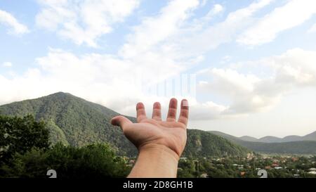 Hand of a man reaching to towards sky. Stock Photo