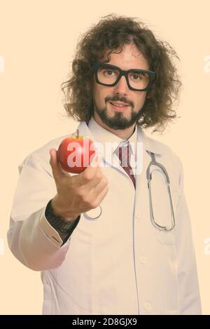 Studio shot of handsome man doctor giving red apple Stock Photo