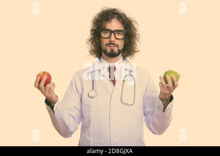Studio shot of handsome man doctor holding red apple and green apple Stock Photo