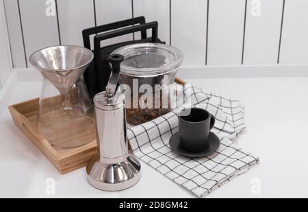 Metal manual coffee grinder. Coffee accessories on the kitchen table. Stock Photo