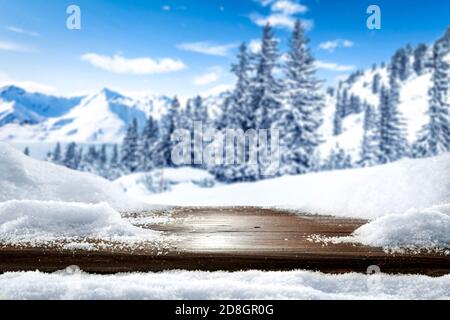 Wooden board table top covered with snow with empty copy space for montage products. Snowy winter concept with space for placing advertising products. Stock Photo