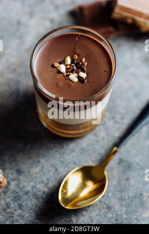 Chocolate dessert, vanilla cream, biscuit and caramel in a glass, on a rustic texture. From above No people Stock Photo