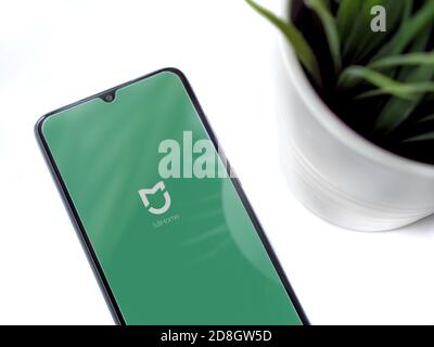 Lod, Israel - July 8, 2020: Modern minimalist office workspace with black mobile smartphone with Mi Home app launch screen with logo on white backgrou Stock Photo