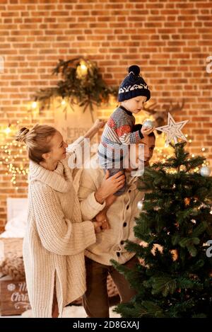 A happy young familyin bedroom decorates the Christmas tree Stock Photo