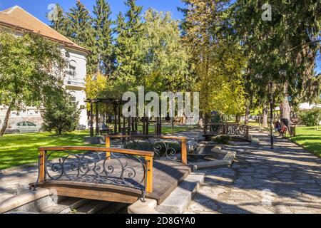 Razlog, Bulgaria - October 20, 2020: Downtown street panoramic view with autumn trees and bridge Stock Photo