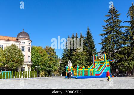 Razlog, Bulgaria - October 20, 2020: Downtown street square panoramic view with autumn trees and people Stock Photo