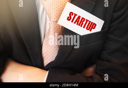 Businessman keeps a card with text Startup in upper pocket of his suit. Business startup marketing concept Stock Photo