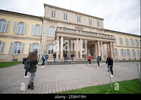 29 October 2020, Baden-Wuerttemberg, Stuttgart: Students in their first semester stand in front of Hohenheim Castle, which belongs to the University of Hohenheim, during a guided tour of the campus. The winter semester 2020/2021 begins in Baden-Württemberg on 2nd November under more stringent hygiene conditions due to the coronavirus pandemic. during a tour of the campus Photo: Sebastian Gollnow/dpa Stock Photo