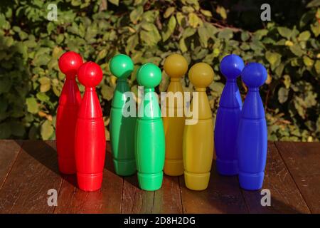 Closeup of colorful plastic toy bowling pins on a wooden floor Stock Photo