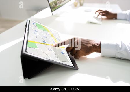 GPS Location Map Online On Tablet. African Man Using Navigator Stock Photo