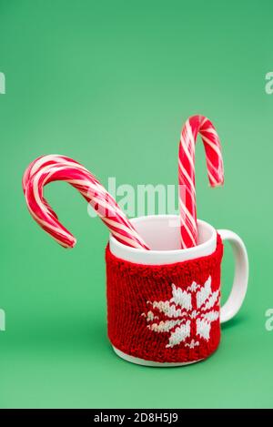 https://l450v.alamy.com/450v/2d8h5j9/two-candy-canes-in-cup-with-knitted-cup-holder-with-snowflake-on-green-background-2d8h5j9.jpg