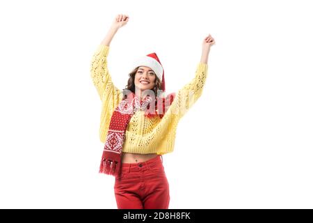young happy woman in santa hat and red scarf standing with hands above head isolated on white Stock Photo
