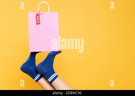Partial view of female legs in socks with print isolated on yellow  background Stock Photo by LightFieldStudios
