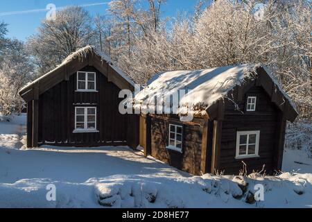 Old wooden cottages in winter landscape Stock Photo