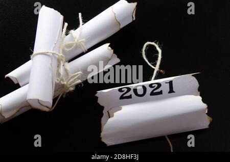 rolls of sheets of paper on a black background. Inscription 2021 Stock Photo