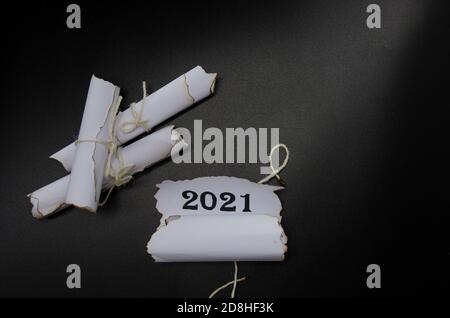 rolls of sheets of paper on a black background. Inscription 2021 Stock Photo