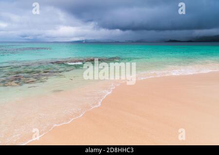 Empty beach. Coastal landscape with azure sea under dark dramatic sky. Atlantic ocean coast, Dominican republic. Samana