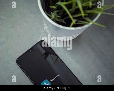 Lod, Israel - July 8, 2020: Modern minimalist office workspace with black mobile smartphone with Adobe Scan app launch screen with logo on marble back Stock Photo