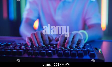 Close-up on the Hands of the Gamer Playing in the Video Game Using Keyboard. Hacker Breaks into System. Stock Photo