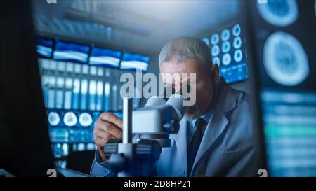 Senior Medical Research Scientist Looking under the Microscope in the Laboratory. Neurologist Solving Puzzles of the Mind and Brain. In the Laboratory Stock Photo
