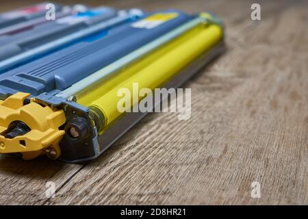Yellow color toner cartridge for color laser printer on wooden table Stock Photo