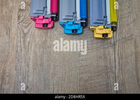 Three toner cartridges for color laser printer stacked on wooden table Stock Photo