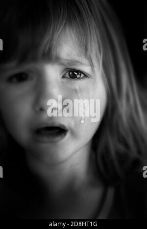 Portrait of little girl crying with tears rolling down her cheeks dramatic and emotional Stock Photo