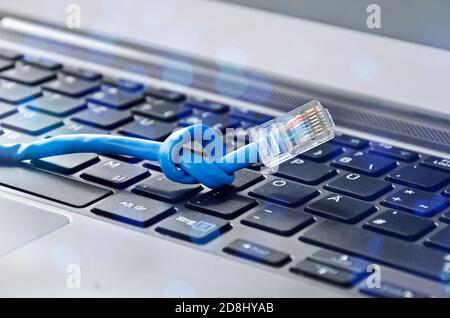 Internet cable with knot on a computer keyboard symbolising bandwidth problems Stock Photo