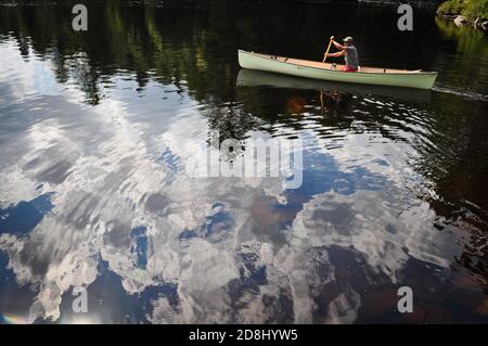 Clouds reflected in the water, Canoeing in Ontario's Algonquin ProvinciaL PARK, ONTARIO, CANADA. Stock Photo