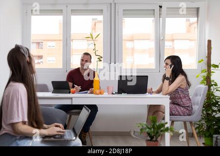 Happy man and women smiling and talking while working in modern office together Stock Photo