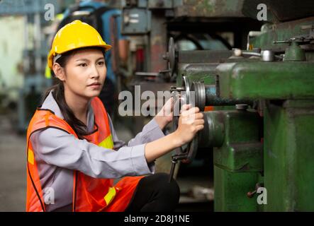 Female Engineers operating a cnc machine in factory Stock Photo