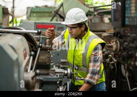 Engineers operating a cnc machine in factory Stock Photo