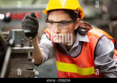 Female Engineers operating a cnc machine in factory Stock Photo