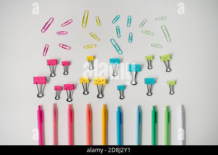 colorful office supplies arranged in rainbow on white table Stock Photo