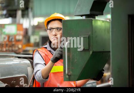 Female Engineers operating a cnc machine in factory Stock Photo