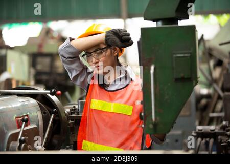 Female Engineers operating a cnc machine in factory Stock Photo