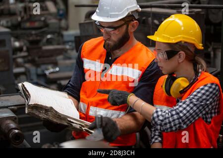 Engineers operating a cnc machine in factory Stock Photo