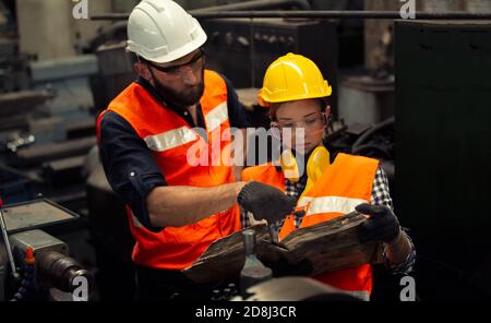 Two Engineers reading manual to operating machine in factory Stock Photo