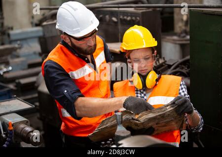Engineers operating a cnc machine in factory Stock Photo