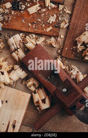 A hand planer and wood shavings on the tile floor Stock Photo